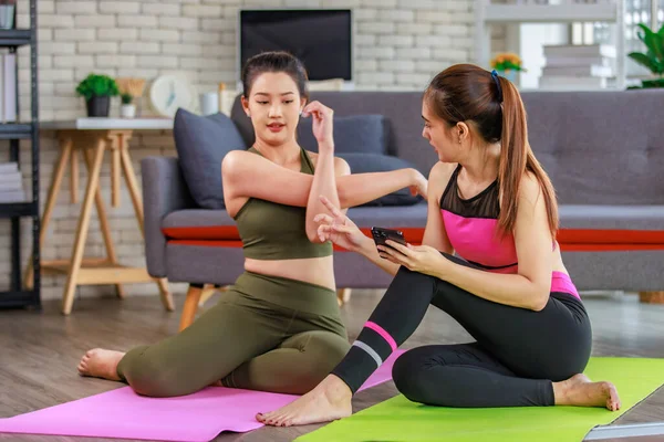 İki bin yıllık Asyalı genç, güzel, sağlıklı, zayıf, güçlü, seksi, spor kıyafetleriyle spor mankenler evde antreman yaptıktan sonra gülümseyerek otururlar..