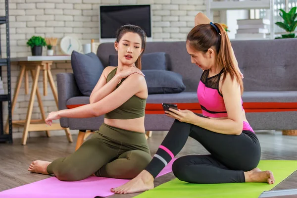 İki bin yıllık Asyalı genç, güzel, sağlıklı, zayıf, güçlü, seksi, spor kıyafetleriyle spor mankenler evde antreman yaptıktan sonra gülümseyerek otururlar..