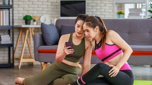 İki bin yıllık Asyalı genç, güzel, sağlıklı, zayıf, güçlü, seksi, spor kıyafetleriyle spor mankenler evde antreman yaptıktan sonra gülümseyerek otururlar..