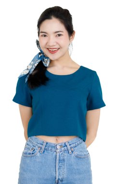 Asyalı güzel, dost canlısı, at kuyruğu saçlı, rahat gömlekli ve kot pantolonlu, el ele tutuşmuş, beyaz arka planda gülümseyen bir kadın modelin portresi..