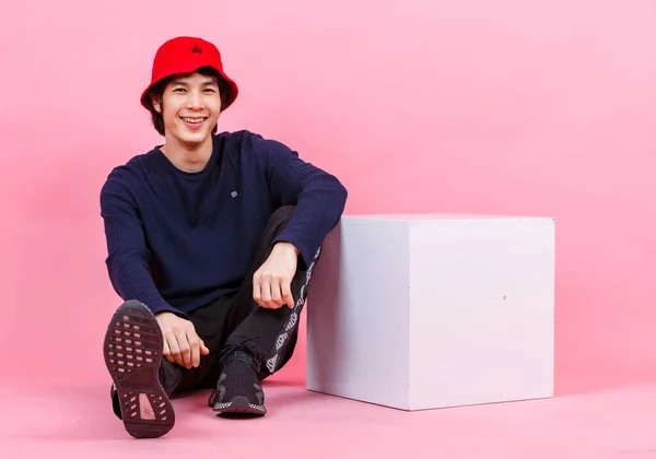 아시아인 청소년 길거리 스타일의 운동화 양동이 분홍색 배경에 상자에 기대어 — 스톡 사진