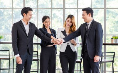 Asyalı mutlu milenyum mutlu fotoğraf grubu profesyonel başarılı erkek işadamı ve kadın iş kadını resmi takım elbiseli karşılıklı gülümseyerek takım çalışmasını gösteriyor..