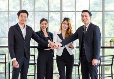 Asyalı mutlu milenyum mutlu fotoğraf grubu profesyonel başarılı erkek işadamı ve kadın iş kadını resmi takım elbiseli karşılıklı gülümseyerek takım çalışmasını gösteriyor..