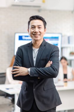 Portrait shot Asian happy cheerful smart confident millennial professional successful male businessman entrepreneur in casual blazer suit standing crossed arms smiling in company office meeting room.