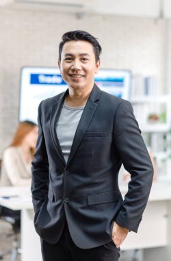 Portrait shot Asian happy cheerful smart confident millennial professional successful male businessman entrepreneur in casual blazer suit standing crossed arms smiling in company office meeting room.