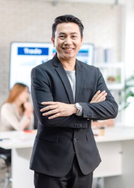 Portrait shot Asian happy cheerful smart confident millennial professional successful male businessman entrepreneur in casual blazer suit standing crossed arms smiling in company office meeting room.