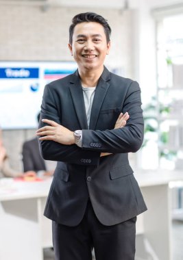 Portrait shot Asian happy cheerful smart confident millennial professional successful male businessman entrepreneur in casual blazer suit standing crossed arms smiling in company office meeting room.