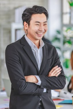 Portrait shot Asian happy cheerful smart confident millennial professional successful male businessman entrepreneur in casual blazer suit standing crossed arms smiling in company office meeting room.