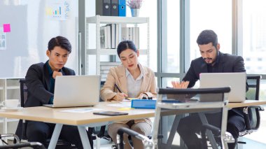 Group of millennial Asian Indian multinational multicultural male and female businessman businesswoman teamwork in formal suit sitting smiling brainstorming meeting together in office conference room.