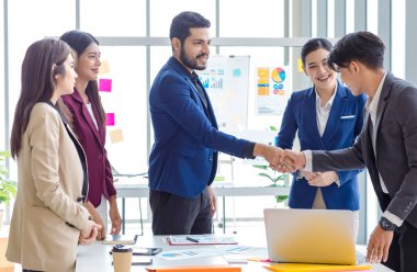 Millennial Indian professional successful bearded male businessman manager entrepreneur in formal suit shaking hand greeting with Asian employee when good job done in multinational company office.