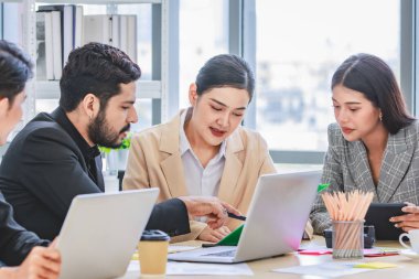 Group of millennial Asian Indian multinational multicultural male and female businessman businesswoman teamwork in formal suit sitting smiling brainstorming meeting together in office conference room.