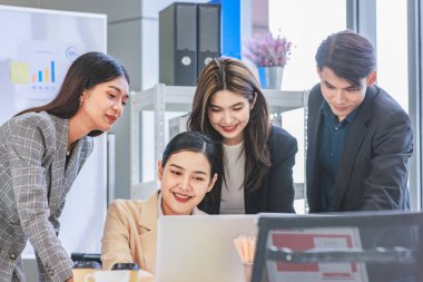 Multicultural multinational millennial Asian female businesswomen Indian male businessman boss in formal suit helping working brainstorming together with laptop computer in conference meeting room.