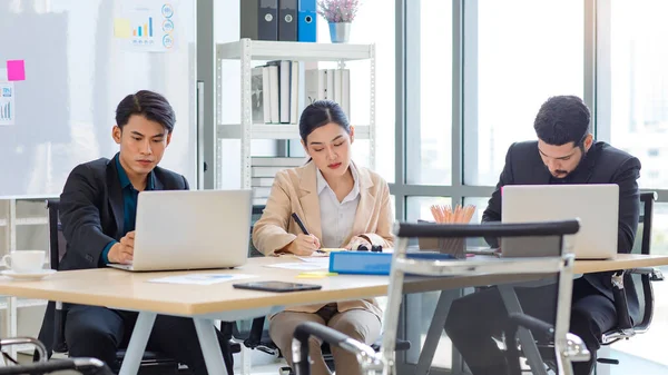 Group of millennial Asian Indian multinational multicultural male and female businessman businesswoman teamwork in formal suit sitting smiling brainstorming meeting together in office conference room.