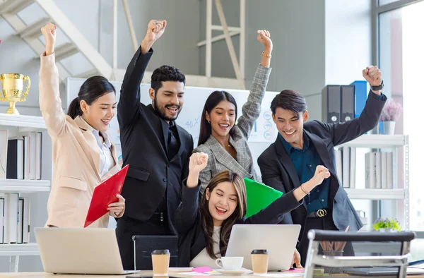 Group of multicultural multinational successful professional cheerful male female businessman businesswoman in formal suit sitting standing smiling holding fists up celebrate job achievement together.