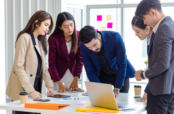 Millennial Indian Asian professional successful male female businessman businesswoman group in formal suit discussing brainstorming sharing business solution ideas in company conference meeting room.