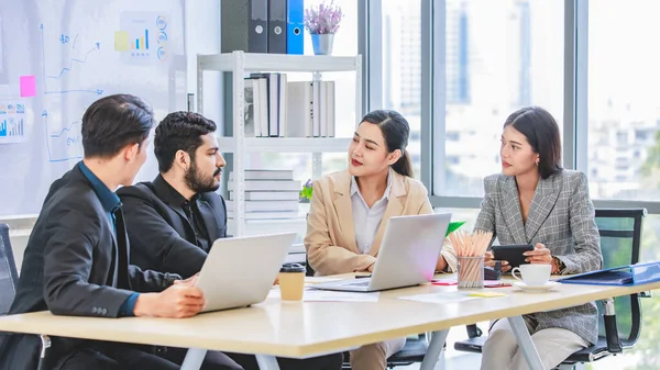 Group of millennial Asian Indian multinational multicultural male and female businessman businesswoman teamwork in formal suit sitting smiling brainstorming meeting together in office conference room.