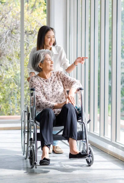 Asian Young Beautiful Cheerful Female Granddaughter Smiling Helping Pushing Old — Stockfoto