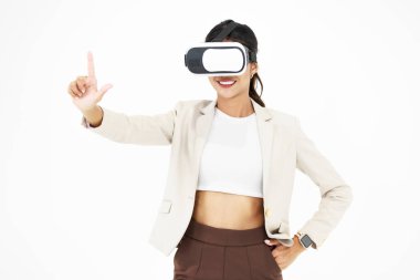 Millennial Asyalı akıllı profesyonel iş kadını CEO 'nun sanal gerçeklik gözlüğü taktığı, el ele tutuşup beyaz arka planda havaya dokunurken gülümsediği bir fotoğraf..