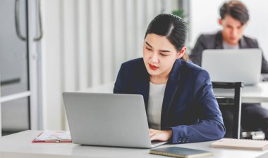 Indian stressed depressed exhausted bearded male businessman sitting at workstation with laptop computer close eyes hold hand on head feeling tired and sleepy after working late overtime last night.