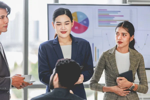 Millennial Indian Asian professional successful male female businessman businesswoman group in formal suit sitting together discussing brainstorming sharing business solution ideas in meeting room.