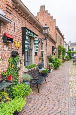 Hollanda 'nın Buren kentindeki eski kale kasabasında çiçeklerle ve bitkilerle dolu rahat bir cadde.