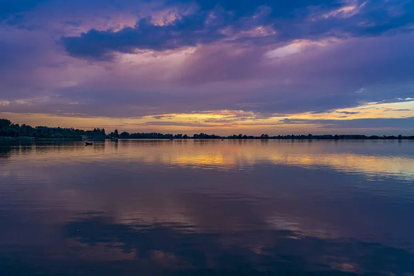 stock image On this almost windless evening the last boats sail back to the harbor and the just set sun creates beautiful colors in the sky