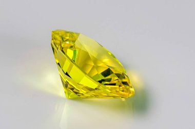 Detail photo (focus stacking) of a self-cut Synthetic Corundum with Light Yellow nr20sp color and Omni Oval 1.33.1 cut, placed on a white acrylic glass surface with the crown facing top right