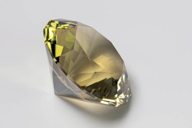 Detail photo (focus stacking) of a self-cut Quartz with Prasiolite color and Vertical split mains cut, placed on a white acrylic glass surface with the crown facing top right