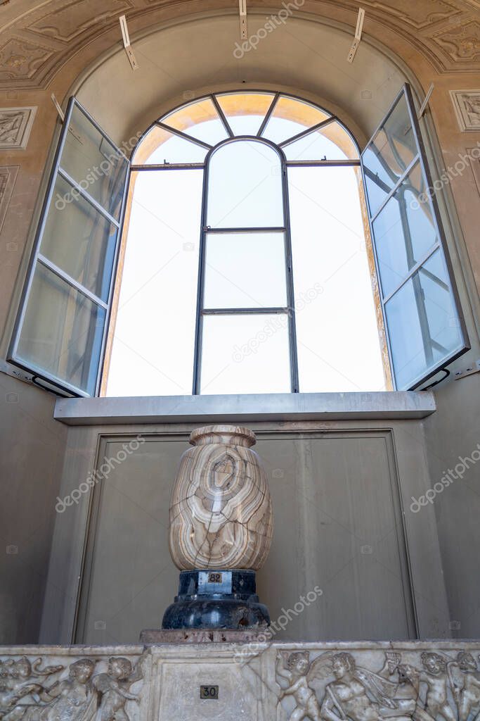 A marble vase under an open window in one of the museums in Vatican City, Rome