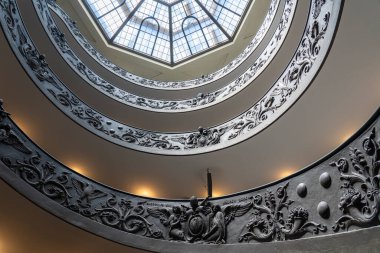 Bottom view of the twisted staircase (Momo Bramante Staircase) with the beautiful details and the glass dome in one of the museums in Vatican City, Rome