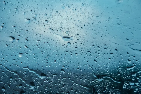 Gotas de agua en movimiento en un vaso de ventana Imagen De Stock