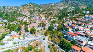 Kıbrıs Rum Kesimi 'nin Limasol ilçesindeki Troodos Dağı' ndaki Agros köyünün hava manzarası. Yukardan seramik kiremit çatılı, kiliseli, kırsal ve kırsal manzaralı geleneksel evlere kuş bakışı bakış açısı.