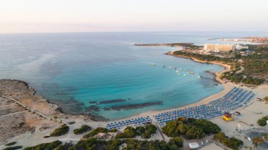 Landa plajı, Ayia Napa, Famagusta, Kıbrıs 'ın havadan kuş bakışı görüntüsü. Gündoğumunda turistlerin uğrak yeri altın kumsaldır. Güneş yatakları, Makronissos ve Agia Napa arasında deniz restoranları vardır. Yaz tatillerinde yukarıdan..