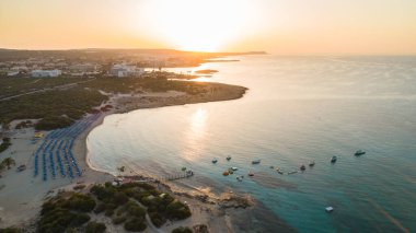 Landa plajı, Ayia Napa, Famagusta, Kıbrıs 'ın havadan kuş bakışı görüntüsü. Gündoğumunda turistlerin uğrak yeri altın kumsaldır. Güneş yatakları, Makronissos ve Agia Napa arasında deniz restoranları vardır. Yaz tatillerinde yukarıdan..