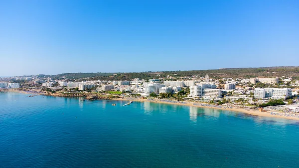 Aerial bird\'s eye view of Sunrise beach at Fig tree in Protaras, Paralimni, Famagusta, Cyprus. The famous tourist attraction family bay with golden sand, boats, sunbeds, restaurants, water sports, people swimming in sea on summer holidays, from above