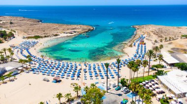 Vathia Gonia plajı, Ayia Napa, Famagusta, Kıbrıs 'ın havadan kuş bakışı görüntüsü. Gündoğumunda, Agia Napa 'da yaz tatillerinde altın kum, güneşlik, deniz restoranları ve deniz restoranlarıyla turistik bölge kayalık körfezi..