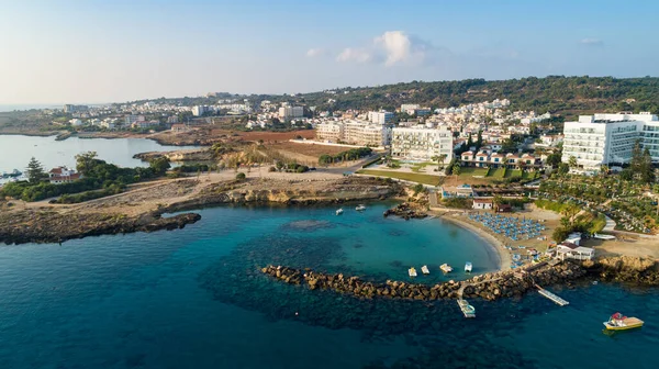 Aerial bird\'s eye view of Green bay in Protaras, Paralimni, Famagusta, Cyprus. The famous tourist attraction diving location rocky beach with boats, sunbeds, restaurants, water sports, people swimming in sea on summer holidays, from above.