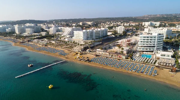 Aerial bird\'s eye view of Sunrise beach at Fig tree in Protaras, Paralimni, Famagusta, Cyprus. The famous tourist attraction family bay with golden sand, boats, sunbeds, restaurants, water sports, people swimming in sea on summer holidays, from above