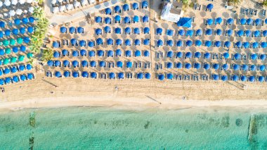 Pantachou 'nun havadan kuş bakışı görüntüsü - Limanaki kumlu plajı (Kaliva), Ayia Napa, Famagusta, Kıbrıs. Yaz tatillerinde Agia Napa 'da altın kumları, güneş şemsiyeleri, deniz yatakları, bar restoranları olan turistik bir körfez..