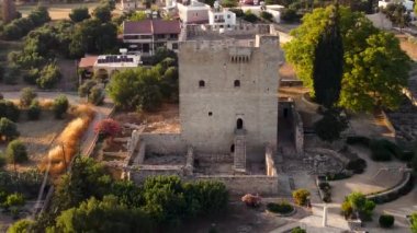 Aerial drone footage close up of the medieval landmark castle of Kolossi, situated in the south of Cyprus, in Limassol from above. View of the village settlement as scene is revealed flying backwards