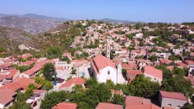 Kıbrıs 'ın Limasol kentindeki Lofou köyünün insansız hava aracı görüntüleri. 360 Hristiyan kilisesi manzarası Panayia Chrysolofitissa, seramik kiremitli çatı mimarisi ve yukarıdan dar sokaklar.