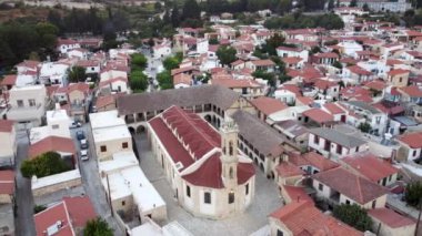 Kıbrıs Rum Kesimi 'nin Limasol kentindeki geleneksel kırsal vadi köyü Omodos' un insansız hava aracı görüntüleri. Timios Stavros (Kutsal Haç) manastırına 360 derece manzara, çatı mimarisi ve yukarıdan dar sokaklar.