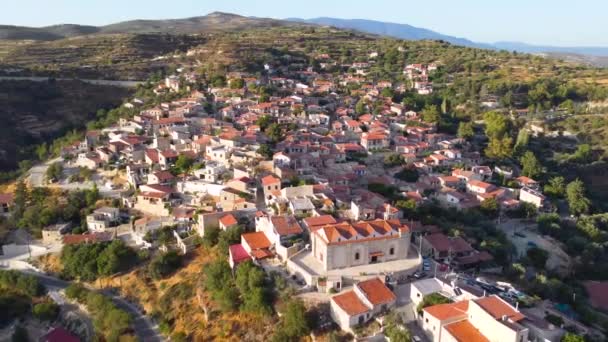 キプロスのLimassolにある伝統的な田舎の丘の上の村Vouniの空中ドローン映像 キリスト教会の360ビューイアニスProdromos セラミックタイル張りの屋根の家 上から狭い通り — ストック動画