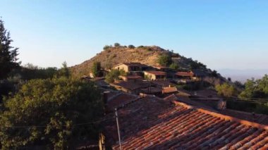 Geleneksel terk edilmiş ortaçağ kırsal köyü Phicardou (Fikardou), Lefkoşe, Kıbrıs Rum Kesimi 'nin hava gün batımı drone görüntüleri. Yukarıdan terk edilmiş seramik seramik kiremitli çatı evleri ve kilise manzarası kurun
