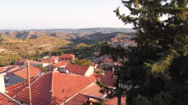 Kıbrıs 'ın Limasol kentindeki Vouni köyünün insansız hava aracı görüntüleri. Hıristiyan kilisesi loannis prodromos, seramik kiremitli çatı evleri ve yukarıdan kaldırımlı caddeler kurun.
