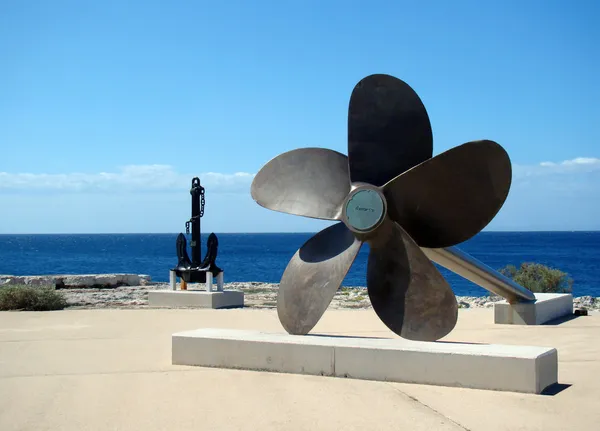 A big propeller and anchor located on the coast — Stock Photo, Image