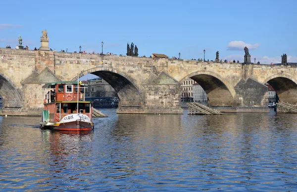 PRAGUE - FEB 23: Tourist boat sailing near the Charles Bridge — Stock Photo, Image