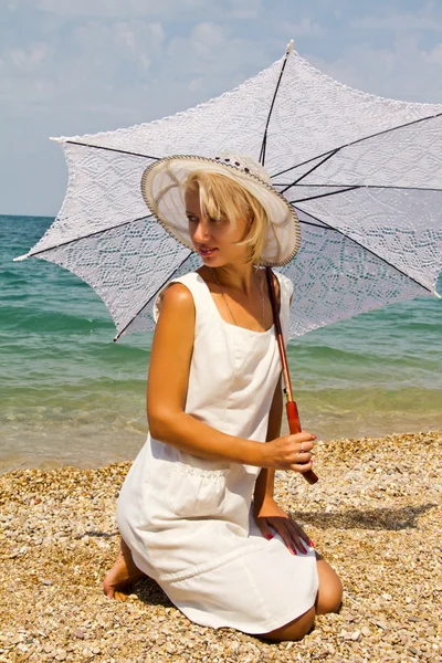 Chica en un sombrero en la playa. — Foto de Stock