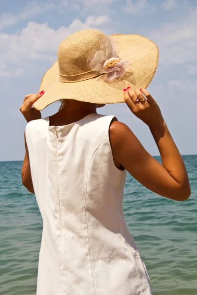 Chica en un sombrero en la playa. — Foto de Stock