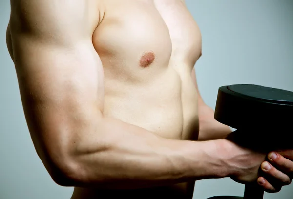 Porträt eines fitten jungen Mannes beim Workout mit schwerer Hantel vor Grunge-Hintergrund — Stockfoto